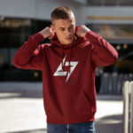 Model wearing Raverge men's red hoodie with the brand logo, showcasing sleek streetwear style.