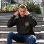 Raverge men's black hoodie Storm Bringer worn by model front minimalist design Poseidon's titles streetwear