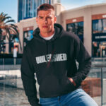 Raverge men's black hoodie Unleashed worn by model red claw marks streetwear style