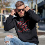 Raverge men's black hoodie Be Iconic worn by model bold typography confident streetwear style