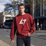 Model wearing men’s Raverge red sweatshirt with minimalist Raverge logo design