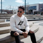 Model wearing men’s Raverge white sweatshirt with minimalist Raverge logo design