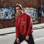 Model wearing the Raverge red Think Without the Box sweatshirt with unique typography design