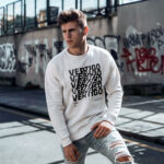 Model wearing men's white sweatshirt with spinning "Vertigo" text design