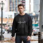 Model wearing Raverge men's Infinite Now black sweatshirt with modern typography