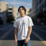 Model showcasing a white streetwear t-shirt with a "Think Without the Box" graphic design, perfect for creative thinkers.