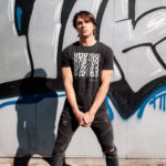 Model wearing black Raverge Vertigo T-Shirt with spinning typography effect.
