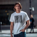 Model wearing white Raverge Vertigo T-Shirt with spinning typography effect.