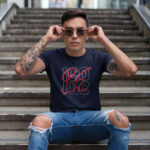Model wearing the navy Be Iconic men’s t-shirt with bold "Be Iconic" text. A powerful, stylish tee for those who want to make an unforgettable impression.