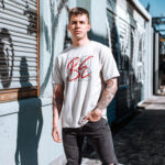 Model wearing the white Be Iconic men’s t-shirt with bold "Be Iconic" text. A powerful, stylish tee for those who want to make an unforgettable impression.