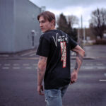 Male model wearing Raverge's 'Verge of Breakthrough' black t-shirt in a streetwear style look