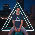 Model wearing navy Raverge Apex T-Shirt with glitch effect triangular design, gamer streetwear