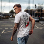 Model wearing white Raverge Bushido T-Shirt with samurai-inspired design and Japanese typography