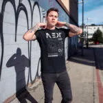 Model wearing black Raverge Next Generation T-Shirt with futuristic graphic and sleek typography
