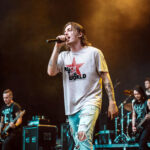 Rocker model wearing Raverge Rock the World T-Shirt with red star graphic and streetwear style