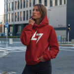 Model wearing Raverge women's red hoodie with the Raverge logo on the chest.