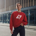 Woman wearing Raverge women's red sweatshirt with Raverge logo.