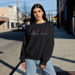 Model wearing Raverge Amour black sweatshirt - Pink heart and script text design