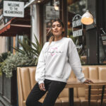 Model wearing Raverge Amour white sweatshirt - Pink heart and script text design
