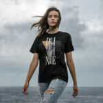 Model wearing Women’s Divine Grace T-shirt with goddess statue design and elegant typography