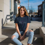 Model wearing Women’s Amour navy t-shirt with elegant typography and heart design