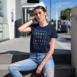 Model wearing Women’s Deny Ordinary navy t-shirt with bold Raverge slogan