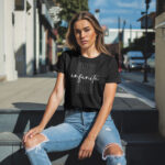 Model wearing Women’s Infinite Now black t-shirt with minimalist typography design