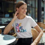 Model wearing Women’s Live Love Laugh t-shirt with bright, colorful text design