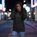 Model wearing Raverge women's black hoodie with the 'New Dimension' futuristic graphic design.
