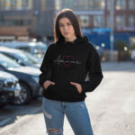 Model wearing Raverge women's black hoodie with "Amour" design.