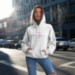Model wearing Raverge women's white hoodie with "Amour" design.