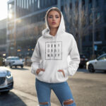 Model wearing Raverge women's white hoodie with "Deny Ordinary" text.