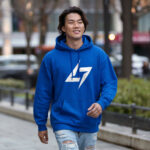 Model wearing Raverge men's blue hoodie with the brand logo, showcasing sleek streetwear style.