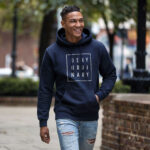 Model wearing Raverge men's navy hoodie Deny Ordinary bold slogan confident streetwear look
