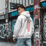 Model wearing Raverge men's white hoodie Verge of Breakthrough bold dynamic streetwear graphic backside view