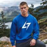 Model wearing men’s Raverge blue sweatshirt with minimalist Raverge logo design