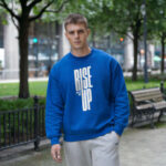 Model wearing Raverge men's Rise Up blue sweatshirt with bold text design