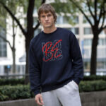 Model wearing Raverge men's Be Iconic navy sweatshirt with bold text design