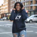 Model wearing Raverge women's navy hoodie with the Raverge logo on the chest.