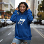 Model wearing Raverge women's blue hoodie with the Raverge logo on the chest.