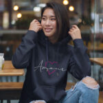 Model wearing Raverge women's navy hoodie with "Amour" design.
