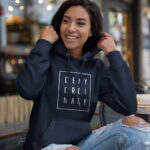 Model wearing Raverge women's navy hoodie with "Deny Ordinary" text.