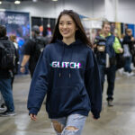 Model wearing Raverge women's navy hoodie with "Glitch" design for gamers and sci-fi fans.