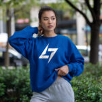 Woman wearing Raverge women's blue sweatshirt with Raverge logo.