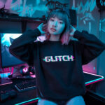 Model wearing Raverge 'Glitch' women's black sweatshirt with glitchy text design, perfect for gamers and sci-fi fans.