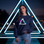 Model wearing Raverge 'Apex' women's navy sweatshirt with a glitched triangle design, suited for gamers and sci-fi fans.